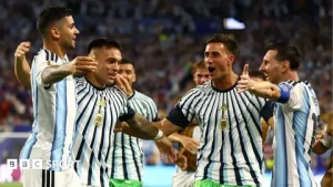Players celebrating a goal during FIFA World Cup 2026 Round of 32 match under stadium lights