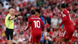 Alexis Mac Allister reacts after Liverpool's penalty is overturned by VAR in the Champions League clash against PSG at Anfield, April 2026.