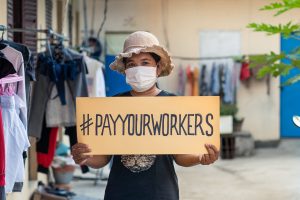 A factory worker in unsafe conditions representing global labour exploitation and workers' rights violations