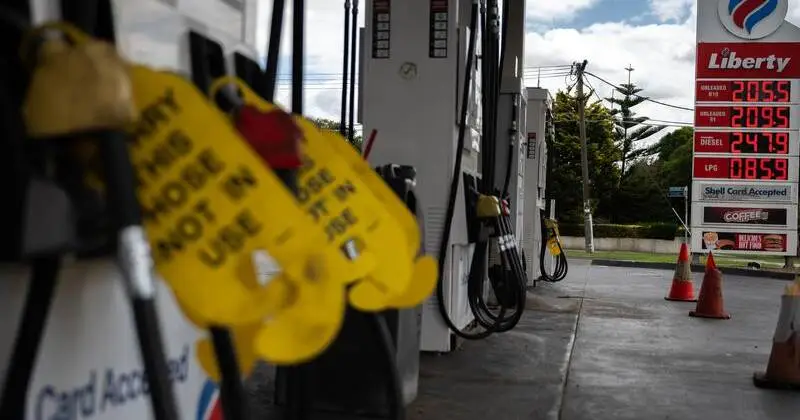 Empty fuel station in Australia during the 2026 fuel crisis warning with long queues and dry pumps