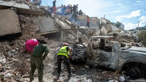 Rescue workers search through collapsed buildings after the Venezuela earthquake as families wait nearby for news of missing relatives.