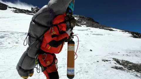 Dawa Sherpa being assisted by rescue team during a high-altitude Everest evacuation mission in extreme weather conditions.