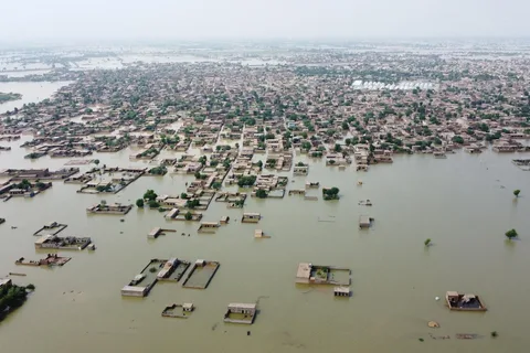 Floodwaters covering roads and farmland in Pakistan during the 2025 monsoon season as residents assess damage.