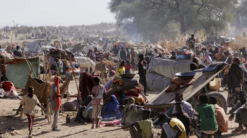 Displaced Sudanese families queue for food and water at a crowded camp in North Kordofan, Sudan