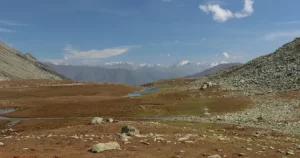 Margan Valley meadow with snow-capped peaks near Margan Top, gateway to Warwan Valley in Kashmir