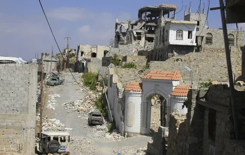 Damaged home standing beside inhabited house on Taiz front line in Yemen