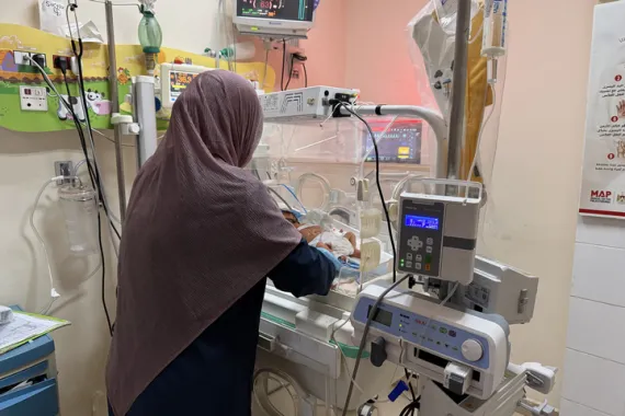 Medical staff work inside a Gaza hospital during a power outage amid ongoing conflict.