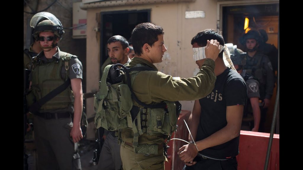Palestinian family holding photo of relative held under administrative detention without charge in Israeli prison
