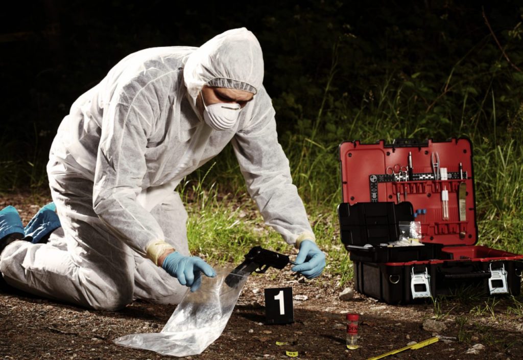 Forensic investigator collecting evidence at a crime scene in Pakistan