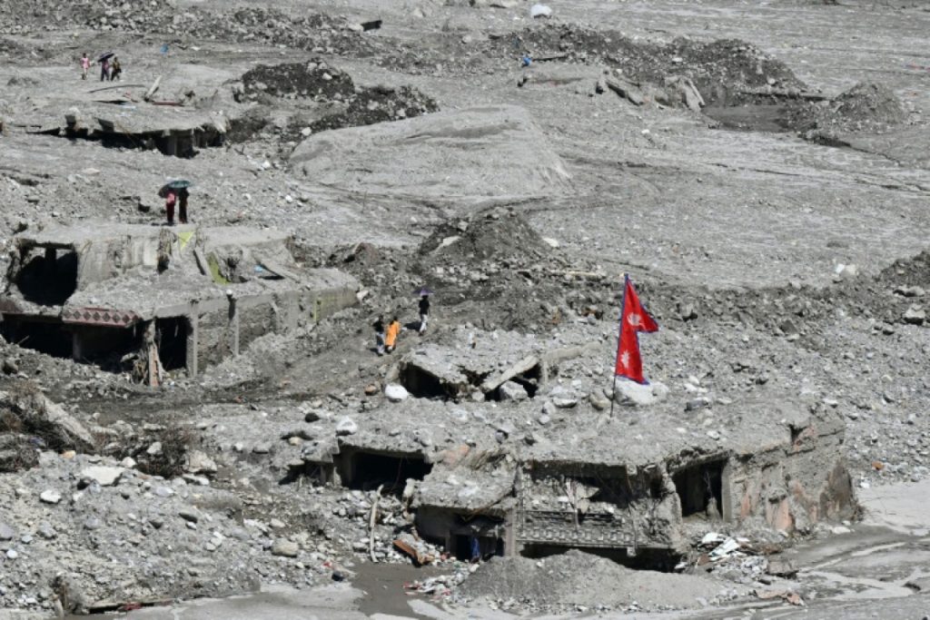 Rescue workers search through mud and debris after Nepal's deadly floods near the Rasuwagadhi border area