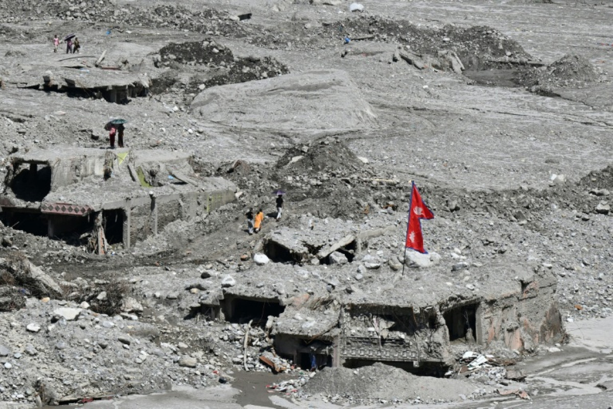 Rescue workers search through mud and debris after Nepal's deadly floods near the Rasuwagadhi border area