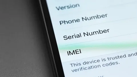 Police officer checking a mobile phone IMEI number during a Lahore crackdown on stolen devices